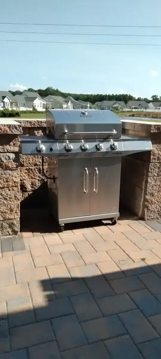Outdoor kitchen island with grill and stone base