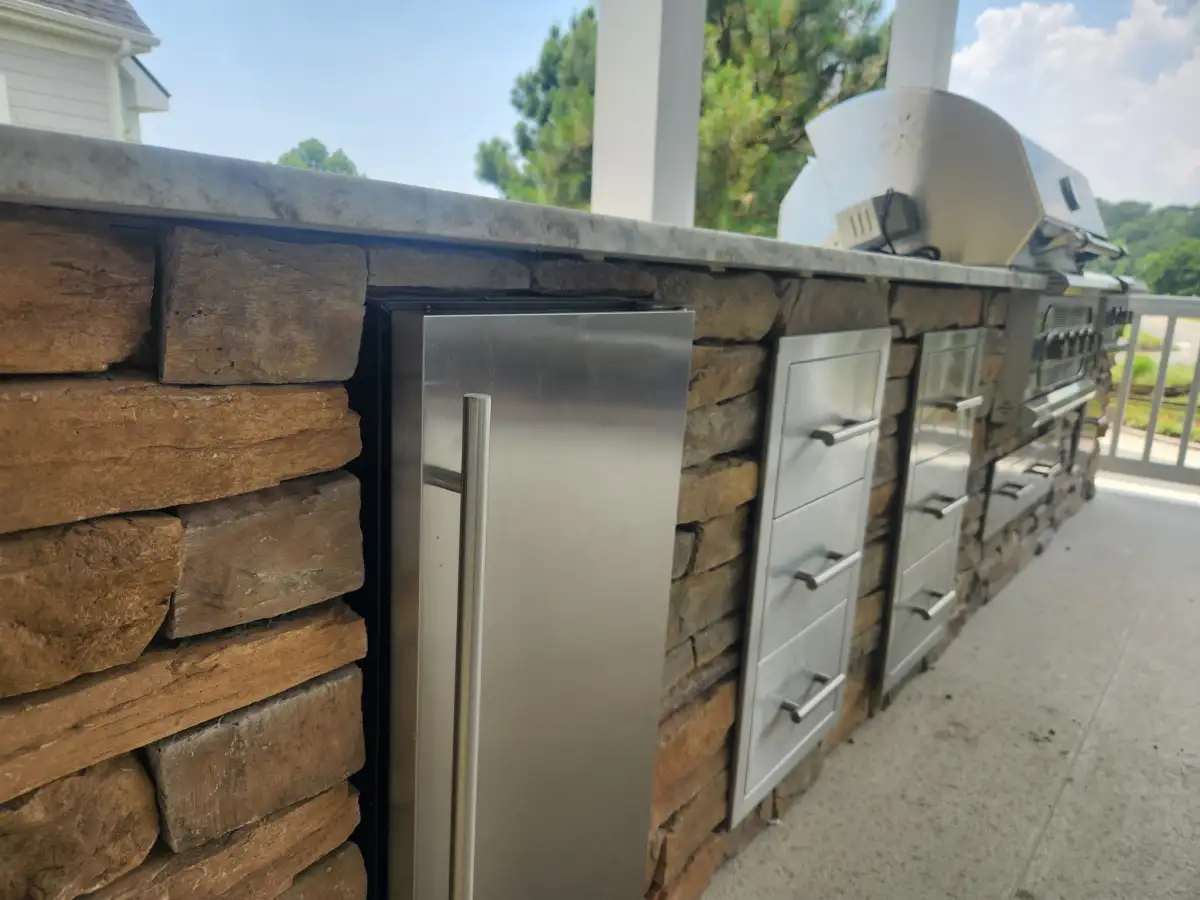 Custom outdoor kitchen with built-in grill and stone countertops