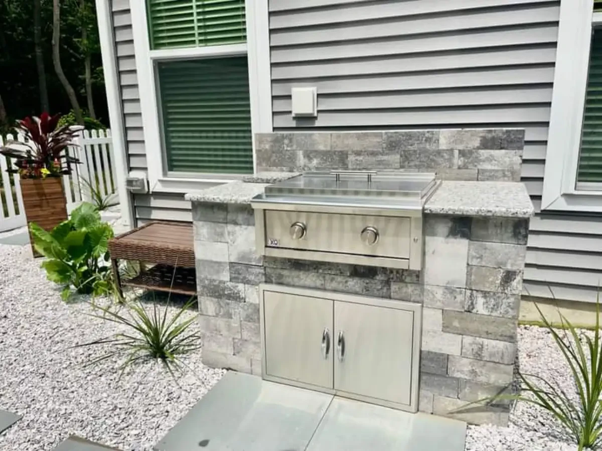 Built-in grill with stone surround and stainless steel cabinet doors
