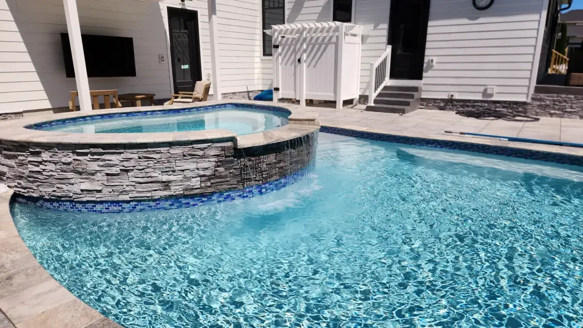 Swimming pool with a raised spa and stone surround